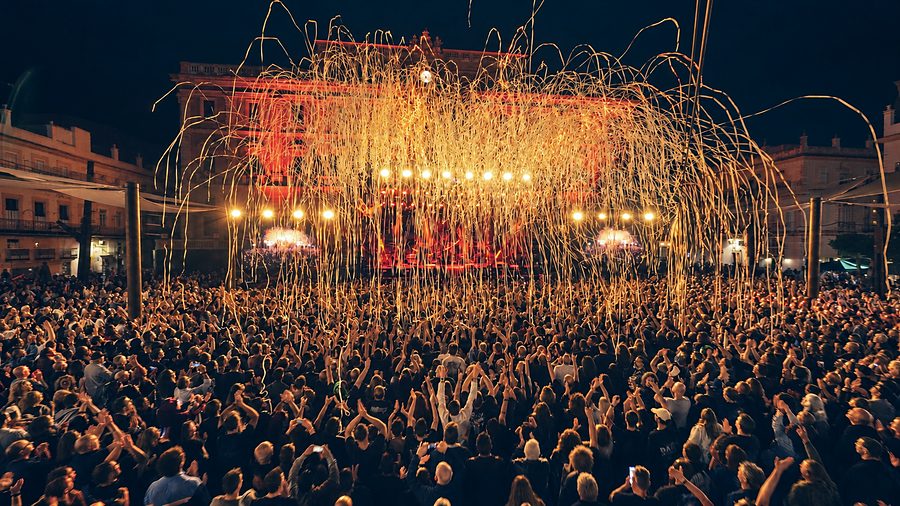 Público de un festival en una plaza con lluvia de confeti frente al escenario