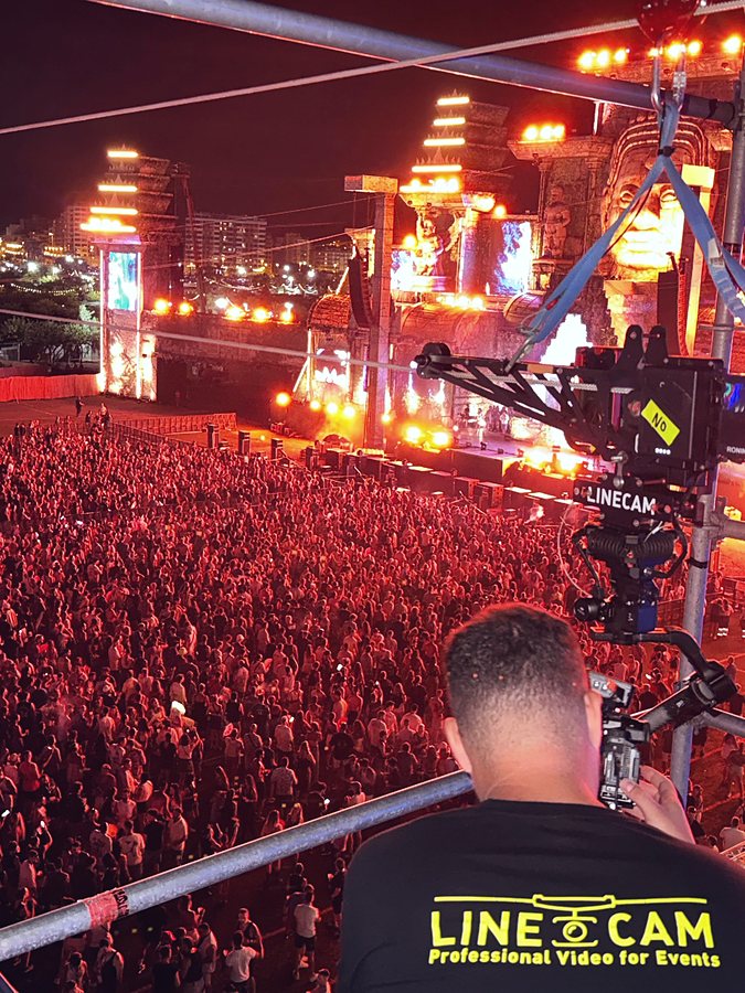 Operador de Linecam® pilotando el cablecam sobre el público de un festival de noche
