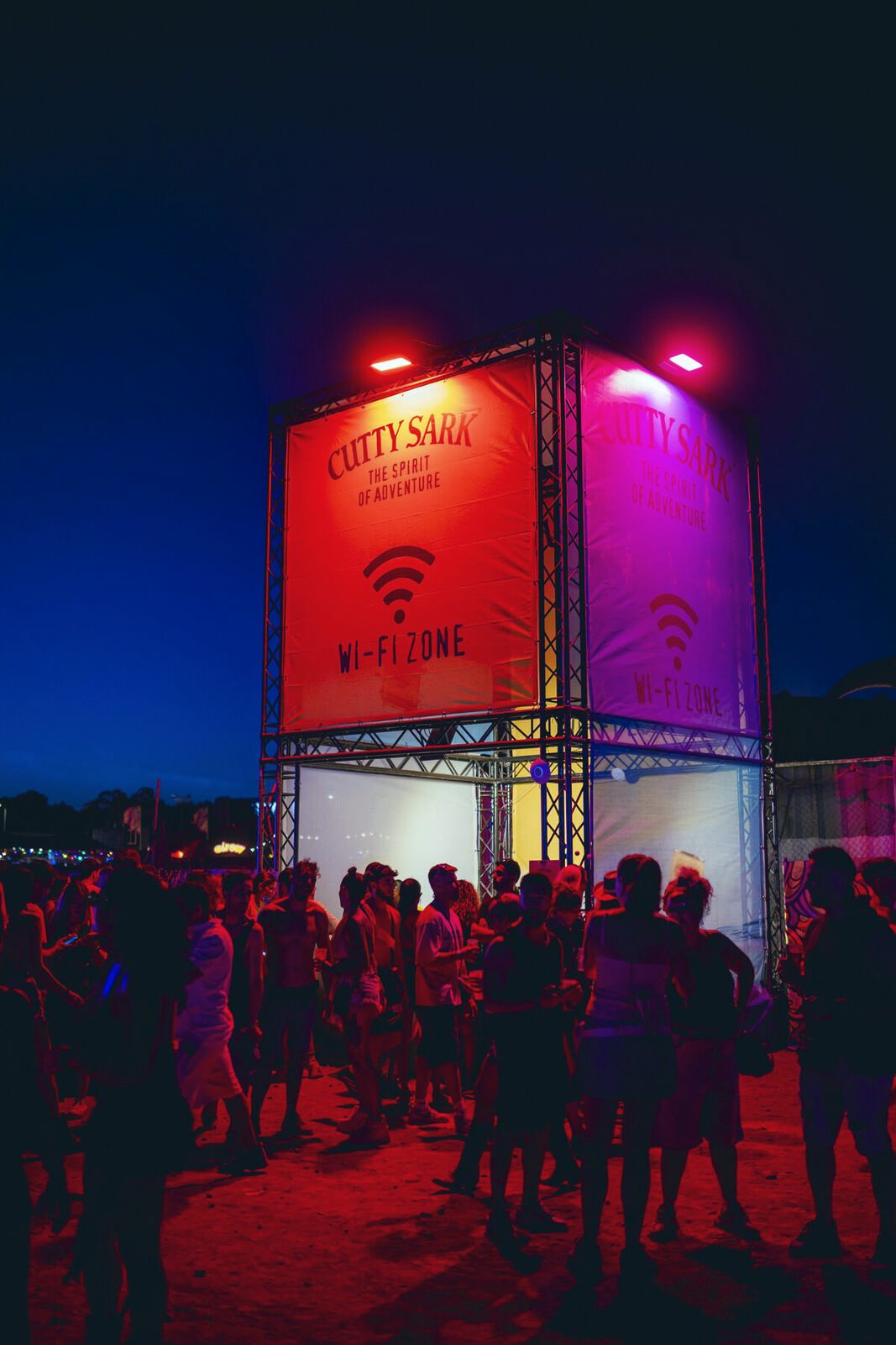 La Wi-Fi Zone iluminada de noche con público alrededor en elrow Málaga